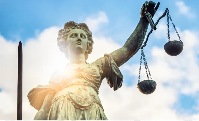 Statue of Lady Justice, a robed woman holding a balance scale, symbolizing impartiality.