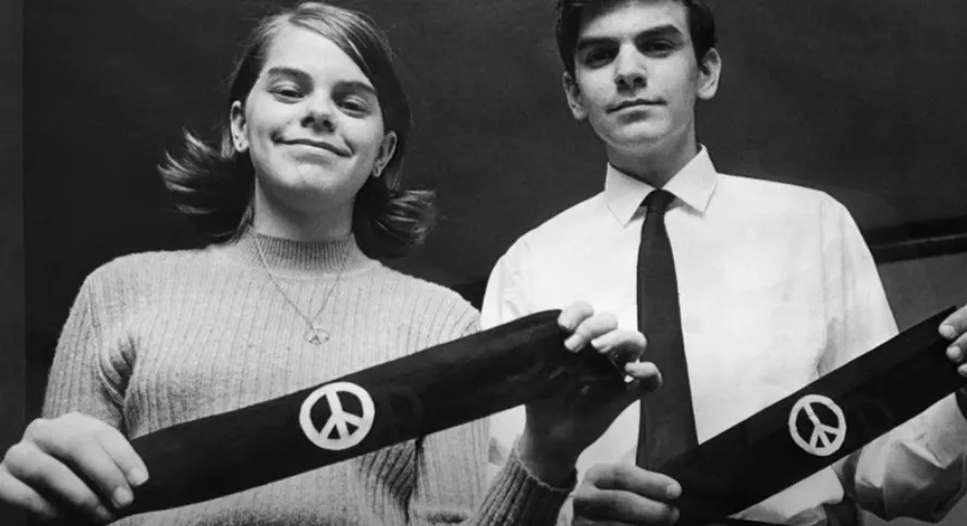 Teenagers holding peace signs. 