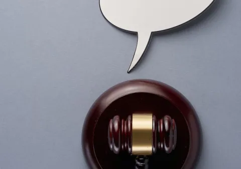 Picture of a gavel in a grey background. 