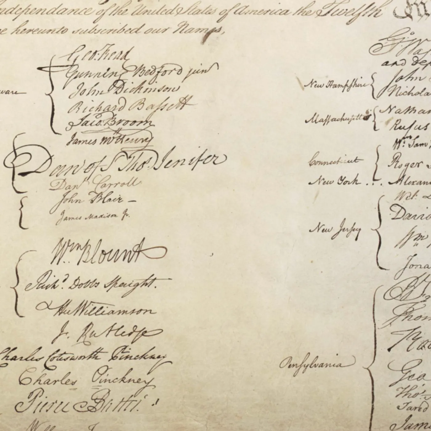 Cropped view of the signature section of the U.S. Constitution, showing handwritten signatures of the delegates organized by state in two columns.